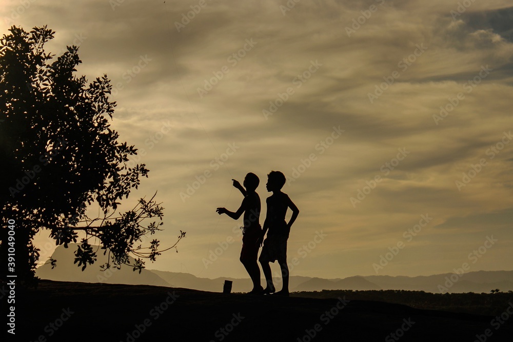 silhouette of kids flying a kite