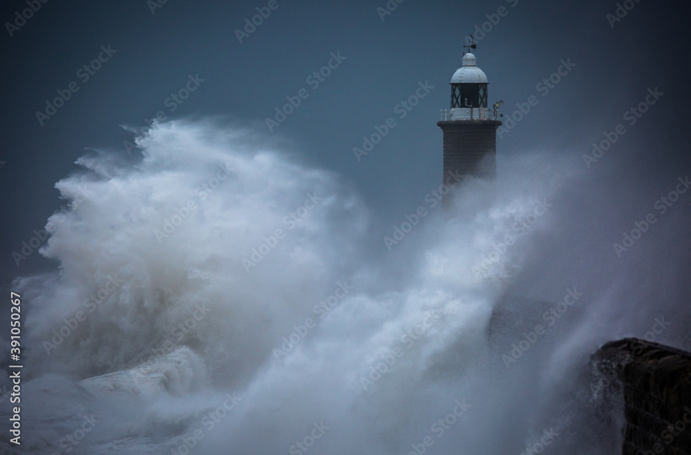 Giant waves batter the lighthouse & north pier guarding the mouth of the Tyne in Tynemouth, England