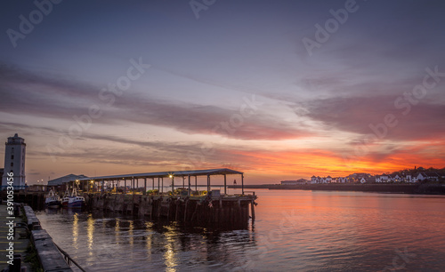 North Shields Fish Quay on a calm morning during a vivid sunrise with moored Fishing boats © Paul Jackson