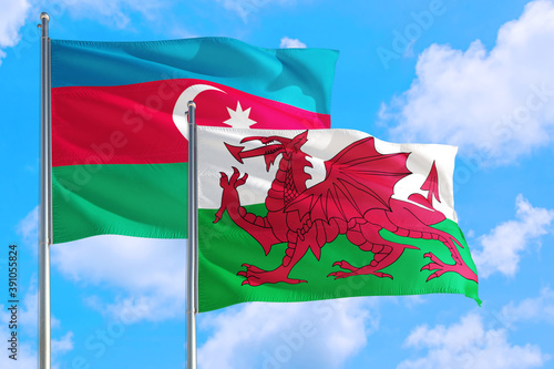 Wales and Azerbaijan national flag waving in the windy deep blue sky. Diplomacy and international relations concept.