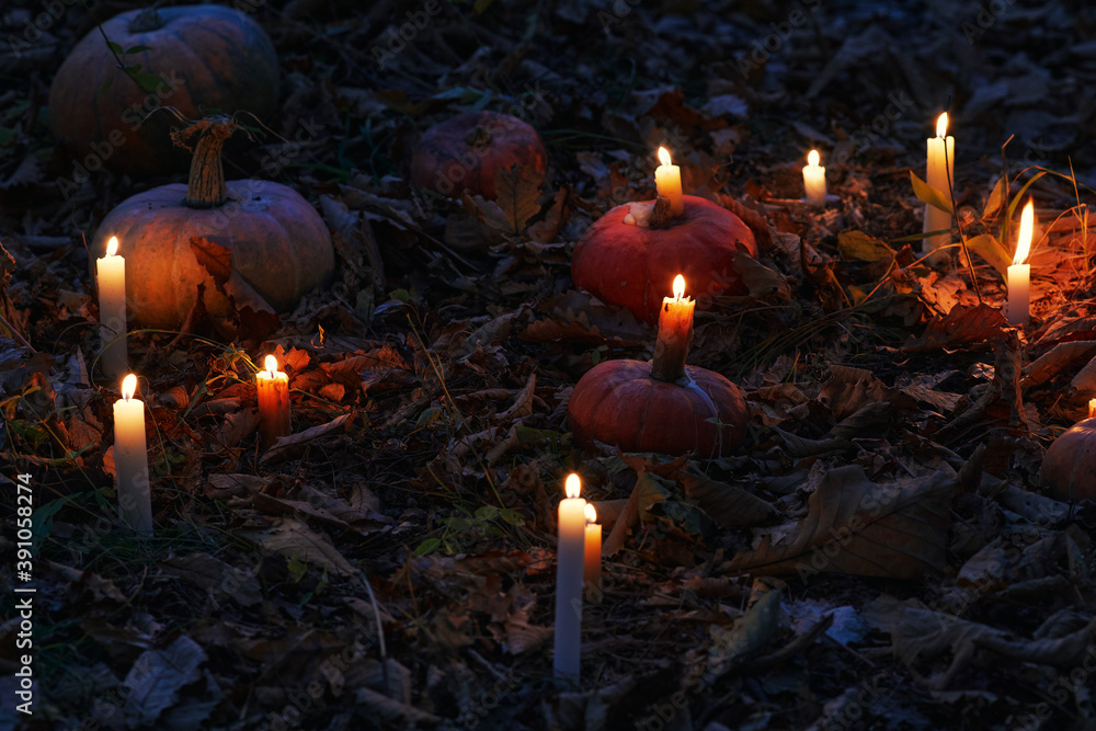 Dark night background with pumpkins, candles and autumn leaves ...