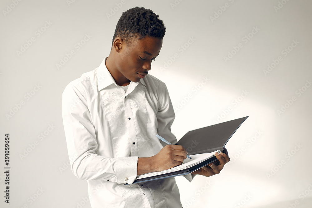 Black man. Guy in a white shirt. Student hold folder with documents in his hands. Black man. Guy in a white shirt. Student hold folder with documents in his hands.