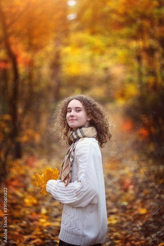 young smiling teenage girl with curly hair on an autumn day in the park young smiling teenage girl with curly hair on an autumn day in the park
