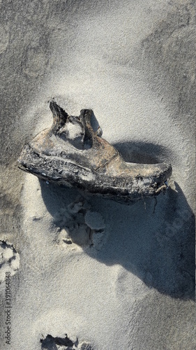 An den Strand gespülter und versandeter Schuh. Biscarrosse. Atlantik. Frankreich. photo