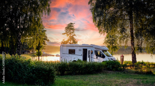 Foto Wunderschönes Sonnenuntergang am See mit einem Wohnmobil beim Campingurlaub in S