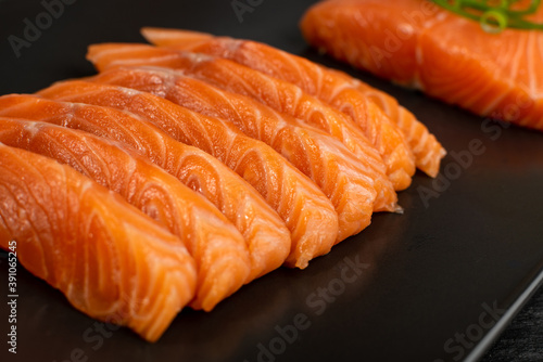Slices of Raw Salmon Fillet on Black Background