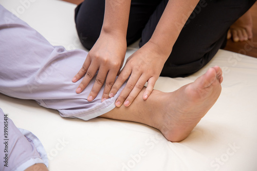 Massager use finger pressures to patient leg for acupressure. Alternative medicine by Thai massage therapy leg pain treatment.