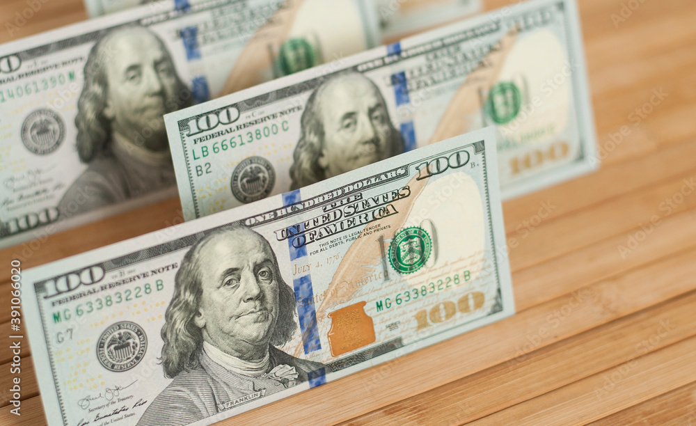 100 Dollars bill and portrait Benjamin Franklin on USA money banknote. Hundred dollar bills on wooden background.. 100 Dollars bill and portrait Benjamin Franklin on USA money banknote. Hundred dollar bills on wooden background..