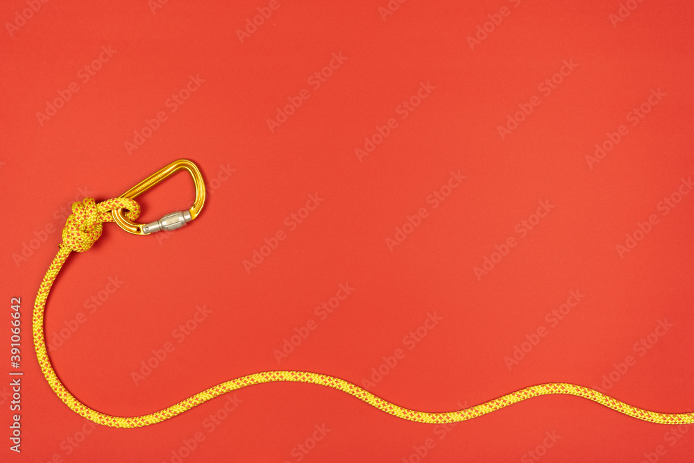 Overhand knot with yellow carabiner and climbing rope on blue background Overhand knot with yellow carabiner and climbing rope on blue background