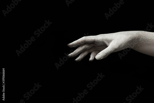 A beautiful female hand of a living sculpture stretches your product on a black isolated background on black Friday, concept art 