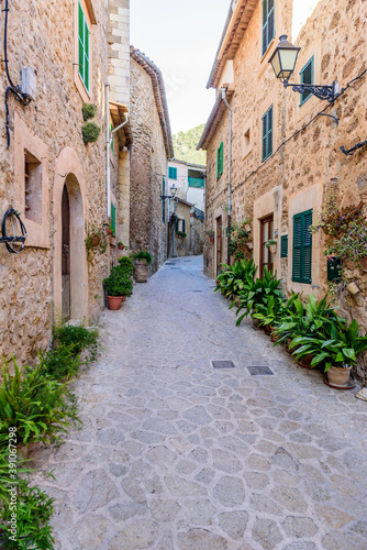 beautiful street with stone buildings decorated with flowers in Valldemossa old town, Mallorca island, Spain