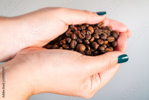Coffee grains in woman hand.