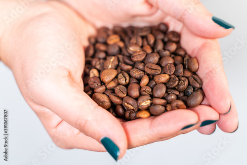 Coffee grains in woman hand.