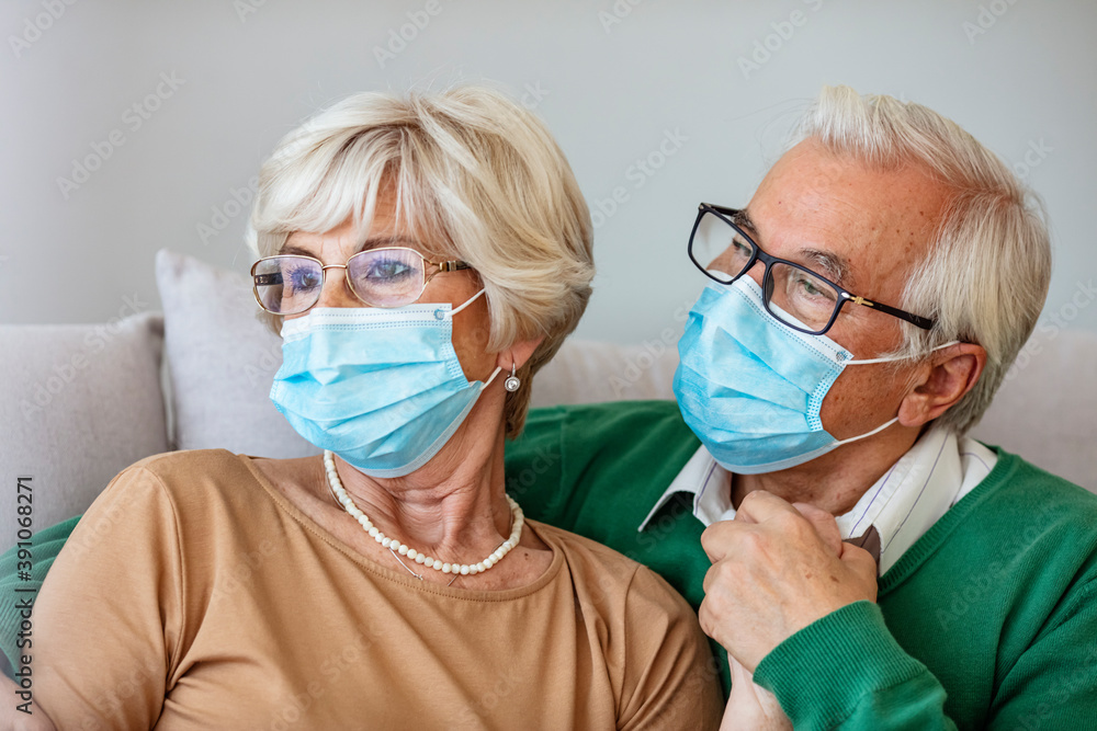 Senior couple wearing facemasks during coronavirus and flu outbreak. Virus and illness protection, home quarantine. COVID-2019. Taking on or taking off masks.