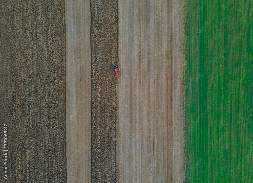 Aerial view of agricultural field modern red tractor plowing land. Aerial view of agricultural field modern red tractor plowing land.