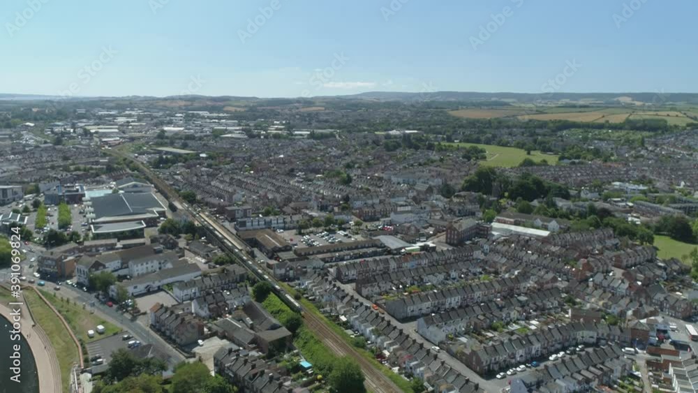 A train makes its way through the city of Exeter. Residential district in the foreground, and an industrial estate in the background A train makes its way through the city of Exeter. Residential district in the foreground, and an industrial estate in the background