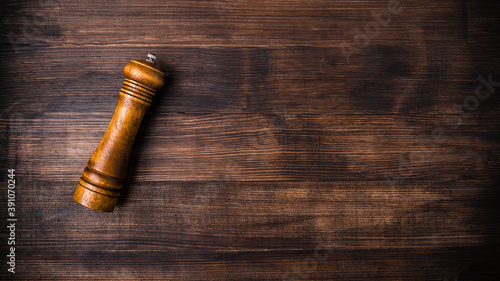 wooden pepper pot on a brown wooden table with free space for text