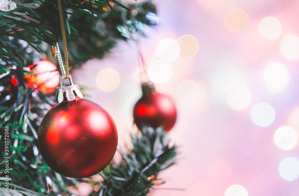 Fototapeta premium Christmas decoration. Red balls hanging on pine branches christmas tree garland and ornaments over abstract bokeh background with copy space