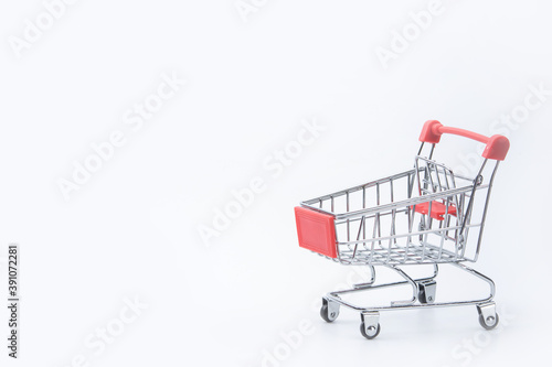 Shopping concept - Red shopping cart on white background with copy space.