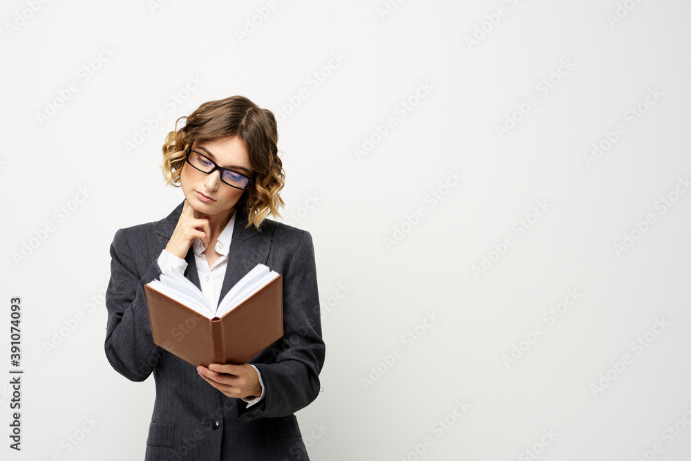Business woman with notepad and glasses work light background cropped view of suit model. Business woman with notepad and glasses work light background cropped view of suit model.