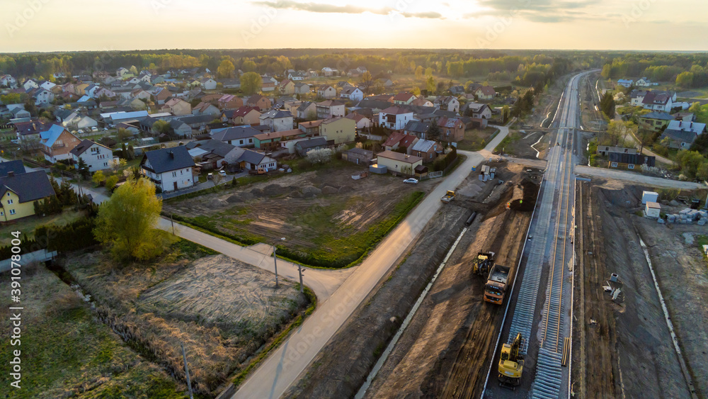 Aerial view on small village located in central Poland. Summer landscape, cloudy afternoon. Green meadows, calm light. Railroad under construction.