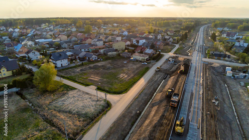 Aerial view on small village located in central Poland. Summer landscape, cloudy afternoon. Green meadows, calm light. Railroad under construction.