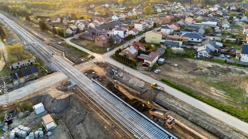 Aerial view on small village located in central Poland. Summer landscape, cloudy afternoon. Green meadows, calm light. Railroad under construction.