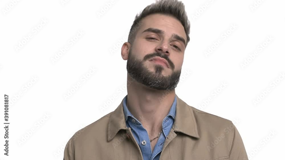 arrogant casual guy in beige jacket pointing fingers to head, laughing and looking to side, pointing fingers and making hand gestures, standing isolated on white background in studio arrogant casual guy in beige jacket pointing fingers to head, laughing and looking to side, pointing fingers and making hand gestures, standing isolated on white background in studio