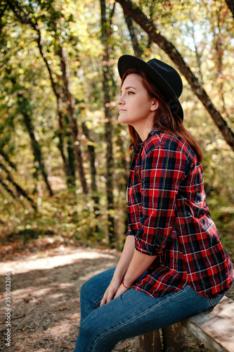 traveler hipster woman standing alone in autumn woods .