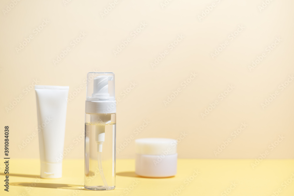 Set of cosmetic skin care products on yellow background with sunlight bright light. Minimal style template Set of cosmetic skin care products on yellow background with sunlight bright light. Minimal style template