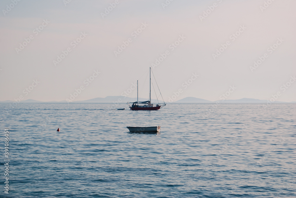 view at the sea with two boats and few small islands on the horizon view at the sea with two boats and few small islands on the horizon