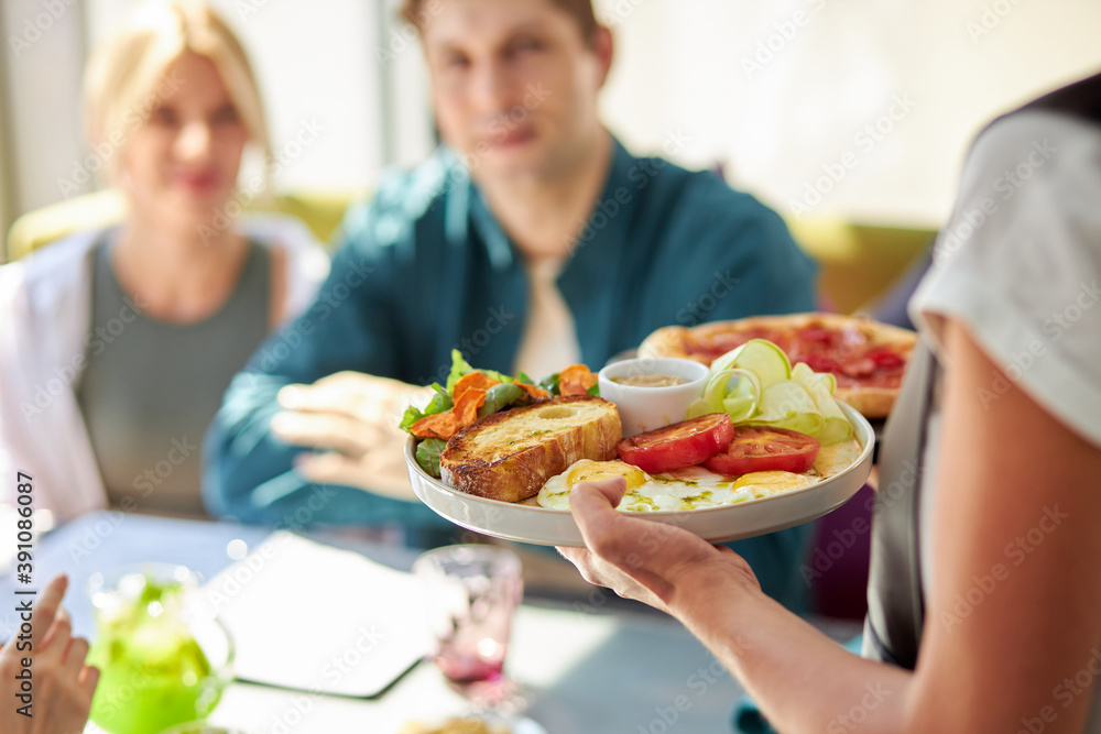 hand of waiter serving lunch at restaurant, eating out in restaurant. waiter in uniform at work. salad on plate hand of waiter serving lunch at restaurant, eating out in restaurant. waiter in uniform at work. salad on plate