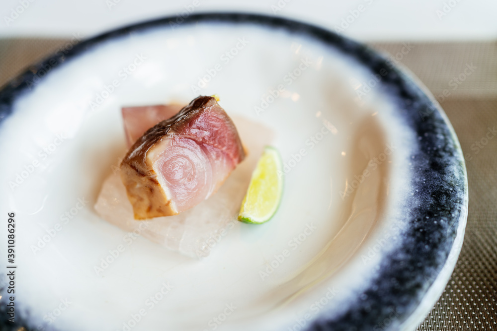 Japanese Omakase meal: closed up Aged Akami Tuna (Lean Tuna) served on Himalayan Salt and sliced lime. Japanese luxury meal.