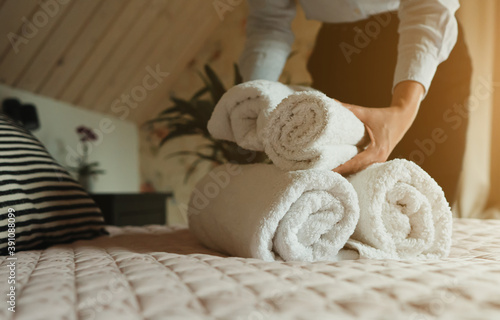 Room service. Woman changing towels in hotel room. photo