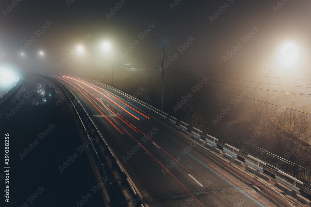 Obraz premium Foggy misty night. Road junction illuminated by street lights