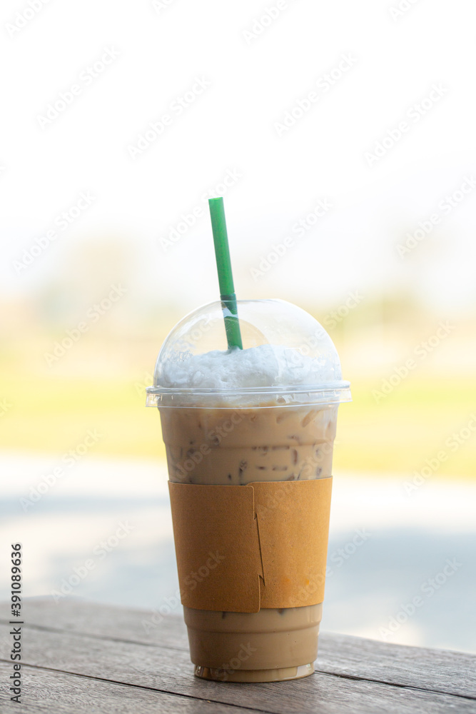 Closeup Plastic glass of iced coffee with milk on blurred background Closeup Plastic glass of iced coffee with milk on blurred background