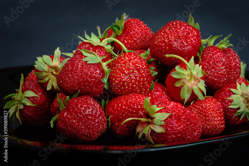 Strawberry closeup. Macro image of fresh strawberries on dark background