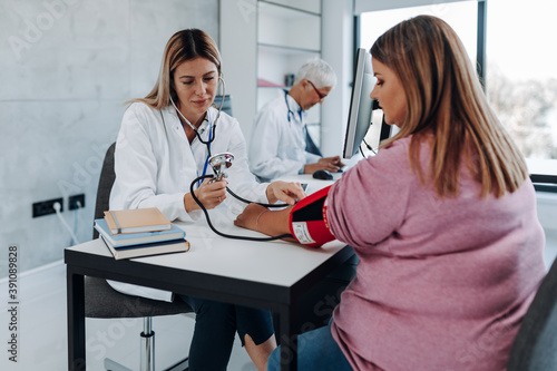 Obraz na płótnie Doctor cardiologist measuring blood pressure of her diabetic patient