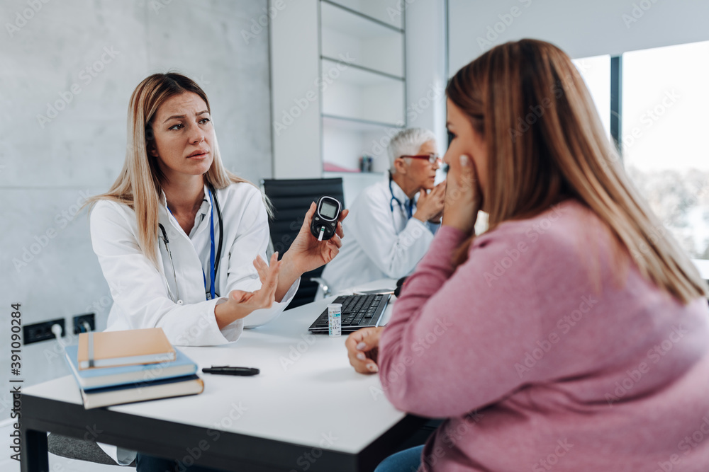 Doctor checking blood sugar level with glucometer of overweight woman. Diabetes test. Healthcare concept. Doctor checking blood sugar level with glucometer of overweight woman. Diabetes test. Healthcare concept.
