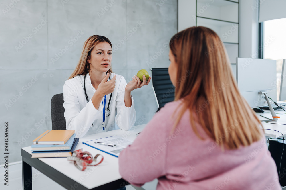 Owerweight woman talking with nutritionist about nutrition and weight loss. Owerweight woman talking with nutritionist about nutrition and weight loss.