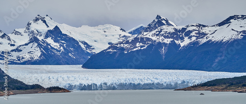 Blue ice of Perito Moreno Glacier in Glaciers national park in Patagonia, Argentina from far away, view from top of a mountain, with Lago Roca in the foreground and snow covered mountains of the Andes