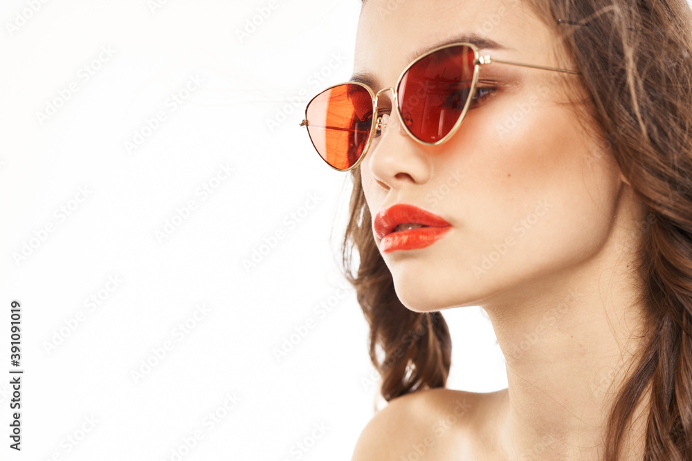 Portrait of brunette woman in sunglasses naked shoulders light background Portrait of brunette woman in sunglasses naked shoulders light background