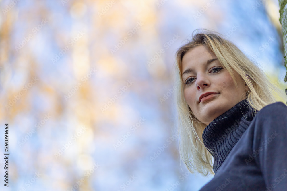 Bottom view of portrait of attractive young woman posing outdoors in autumn. There is enough empty space for your text in the photo. Bottom view of portrait of attractive young woman posing outdoors in autumn. There is enough empty space for your text in the photo.