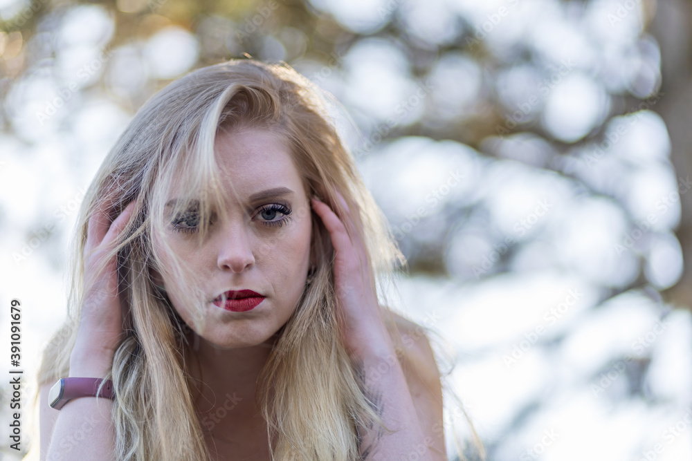 Portrait of stressed young woman holding her head by both hands and looking at the camera. Portrait of stressed young woman holding her head by both hands and looking at the camera.