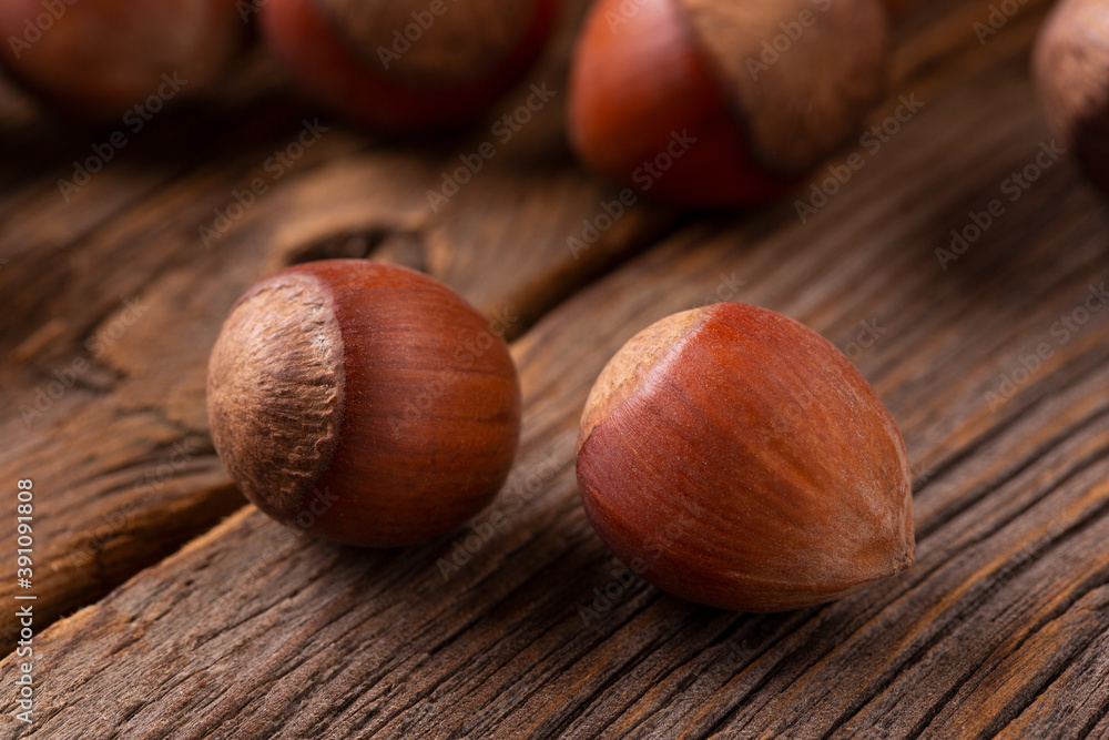 Two hazelnuts on a wooden background. Hazelnut in shell close-up. Two hazelnuts on a wooden background. Hazelnut in shell close-up.