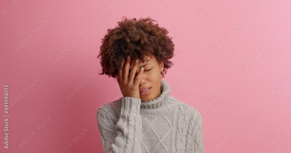 Afro American woman gestures and asks someone demands answer makes face palm with disappointment feels unhappy or frustrated cannot hear what she wants dressed in knitted sweater poses indoor Afro American woman gestures and asks someone demands answer makes face palm with disappointment feels unhappy or frustrated cannot hear what she wants dressed in knitted sweater poses indoor