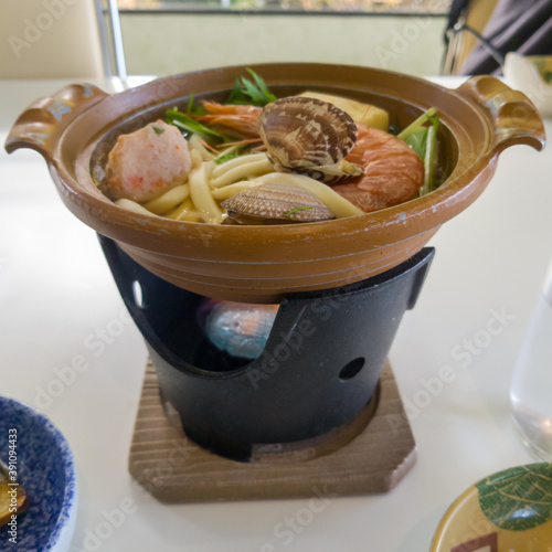 A japanese udon hot pot with various seafood toppings