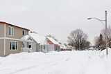 Typical canadian houses with big heaps of snow in front on a cold grey winter day in Gatineau, Quebec, Canada 