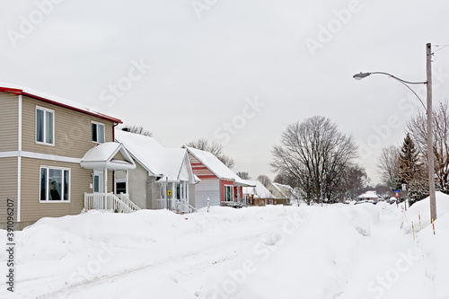 Typical canadian houses with big heaps of snow in front on a cold grey winter day in Gatineau, Quebec, Canada 