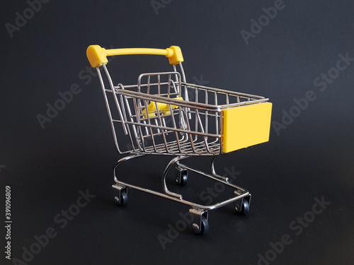Yellow toy cart on black isolated background
